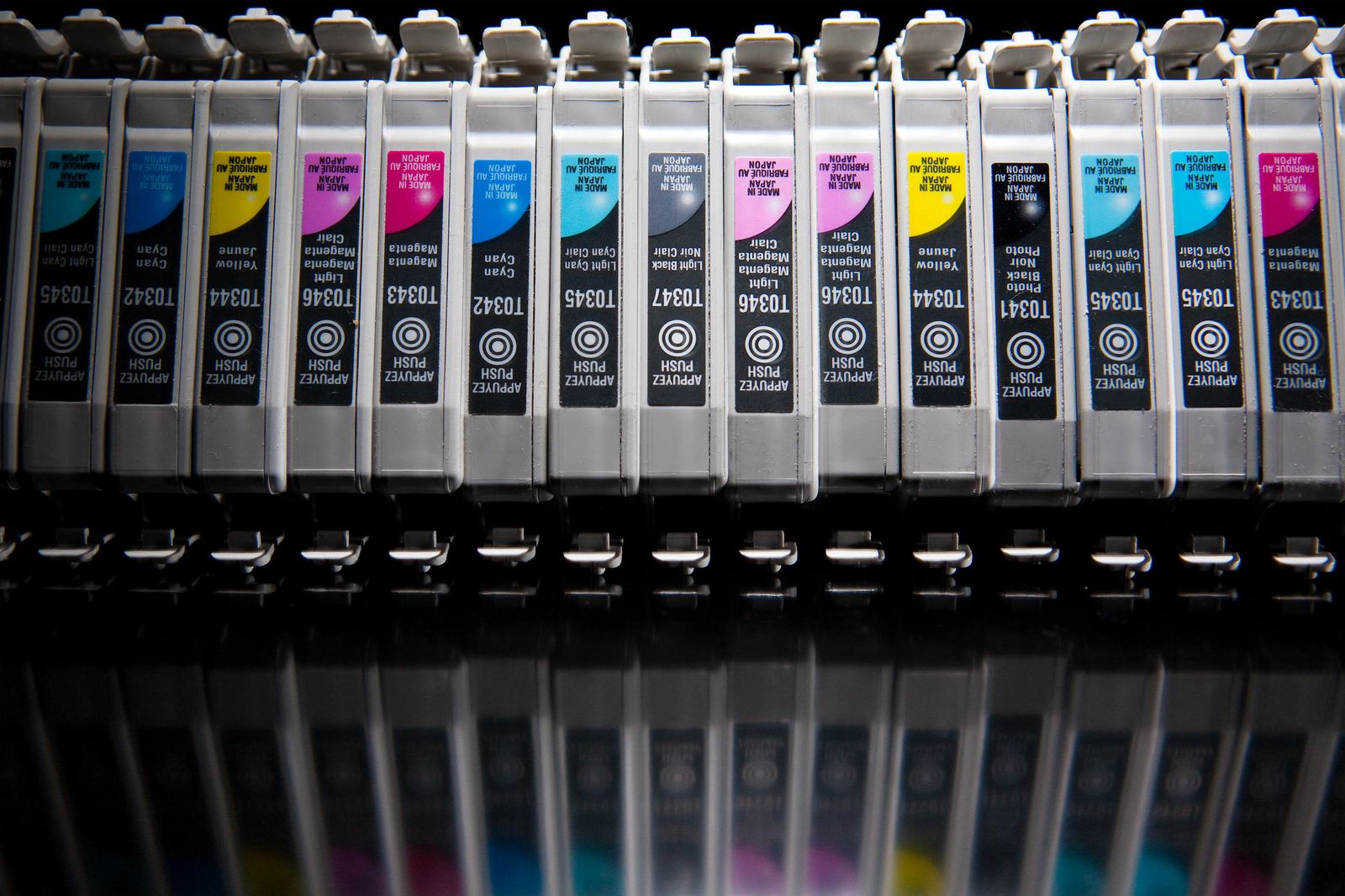 A pile of used inkjet printer cartridges in several colors
